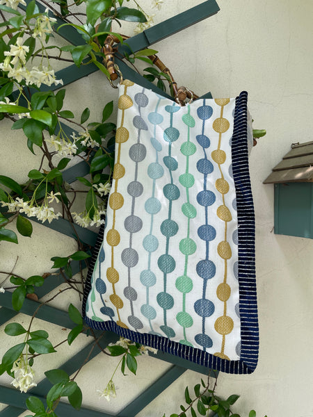 Borsa “contromano” fiori tenui e bolli colorati