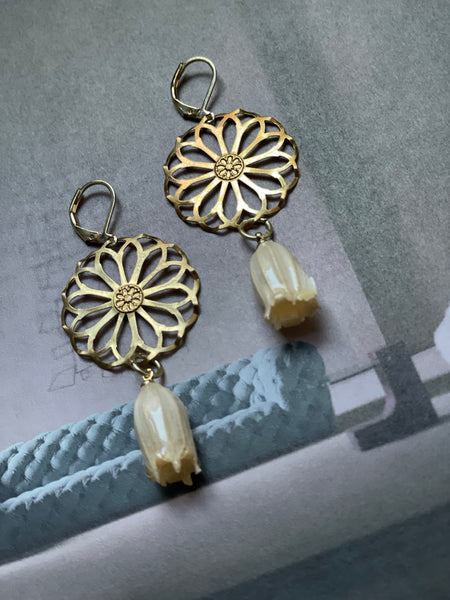 Orecchini ruota e fiore bianco sotto resina