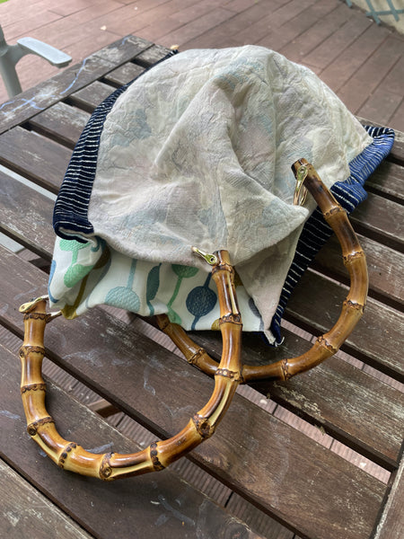 Borsa “contromano” fiori tenui e bolli colorati