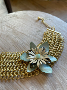 Bracciale a maglia dorato con fiore