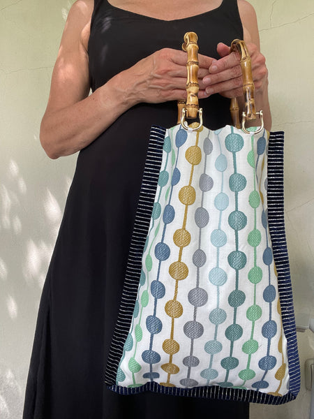 Borsa “contromano” fiori tenui e bolli colorati