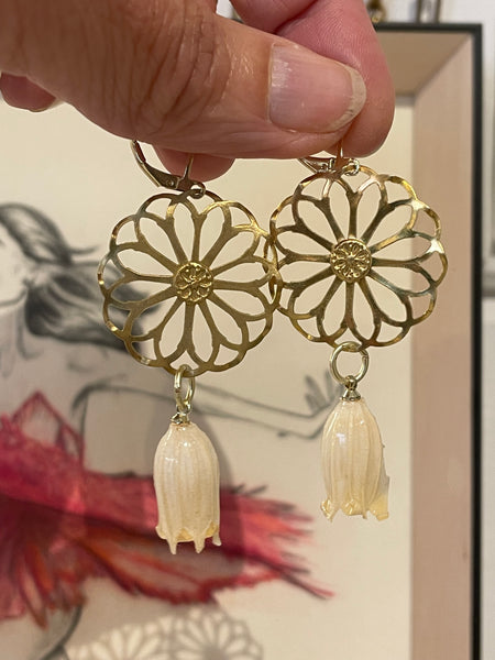 Orecchini ruota e fiore bianco sotto resina